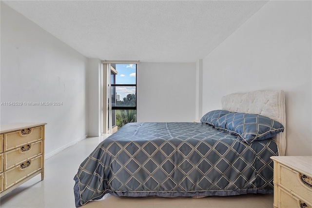 bedroom featuring floor to ceiling windows and a textured ceiling