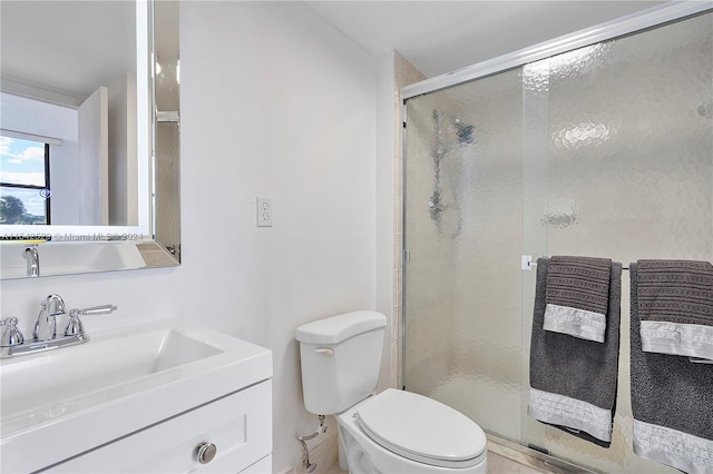 bathroom with an enclosed shower, toilet, and vanity with extensive cabinet space