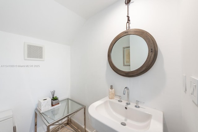 bathroom with visible vents, toilet, and a sink