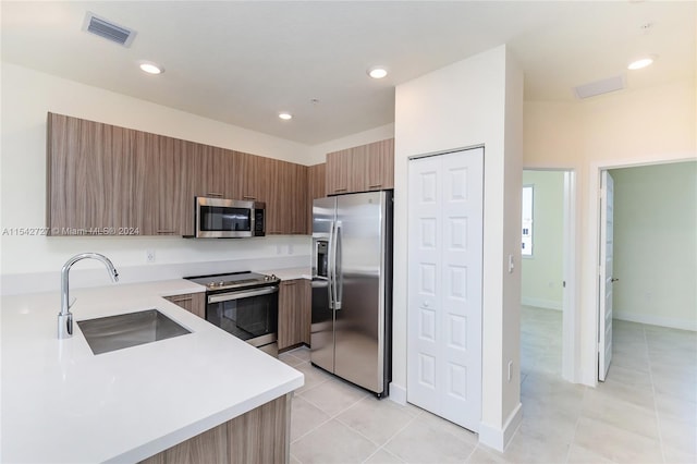 kitchen with light tile floors, appliances with stainless steel finishes, and sink