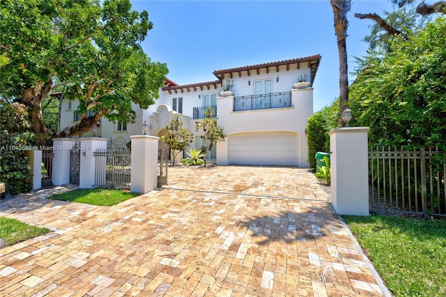 mediterranean / spanish-style house featuring a garage and a balcony