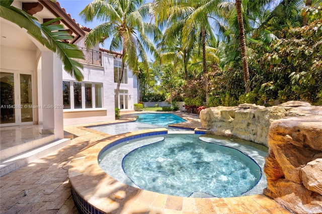 view of swimming pool featuring an in ground hot tub