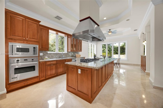 kitchen featuring appliances with stainless steel finishes, sink, a kitchen island with sink, crown molding, and light stone countertops