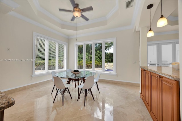 dining area with ceiling fan, ornamental molding, a healthy amount of sunlight, and a tray ceiling