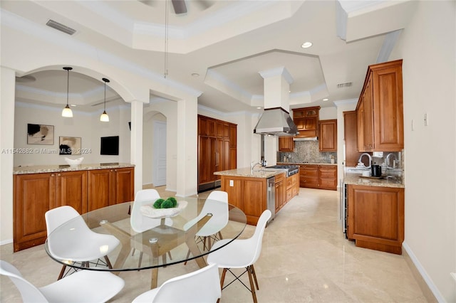 dining space with crown molding, sink, ceiling fan, and a tray ceiling