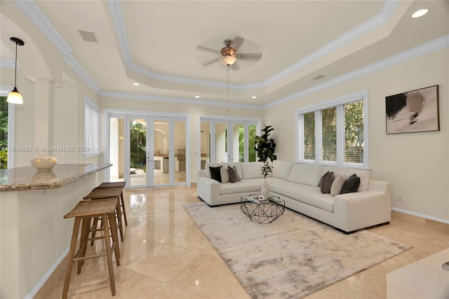 living room featuring a raised ceiling, ornamental molding, ceiling fan, and french doors