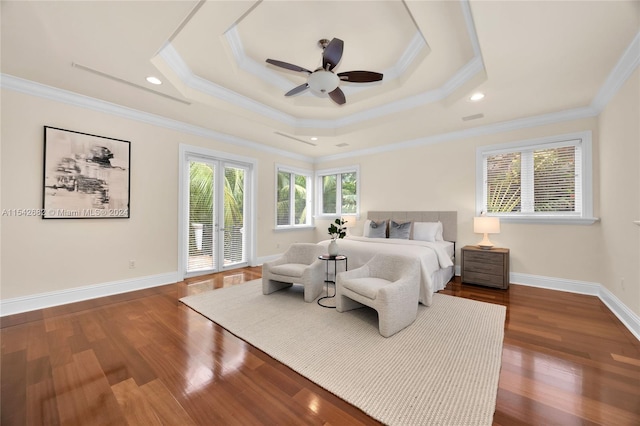 bedroom with ornamental molding, dark hardwood / wood-style floors, and a tray ceiling