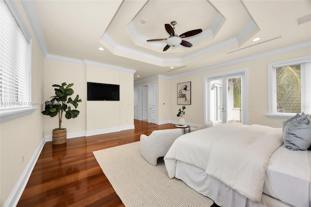 bedroom with dark hardwood / wood-style flooring, a tray ceiling, crown molding, and french doors