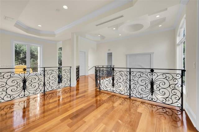 unfurnished room featuring crown molding, hardwood / wood-style floors, and a tray ceiling