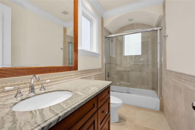 full bathroom featuring shower / bath combination with glass door, tile patterned flooring, vanity, ornamental molding, and toilet