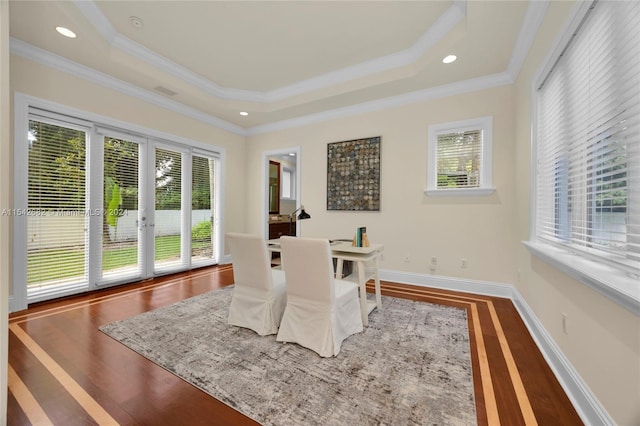 office featuring a raised ceiling, wood-type flooring, and crown molding