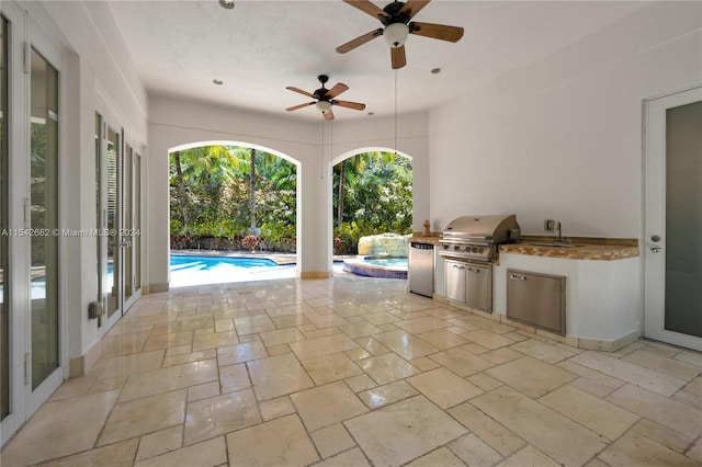 view of patio with area for grilling, sink, and ceiling fan