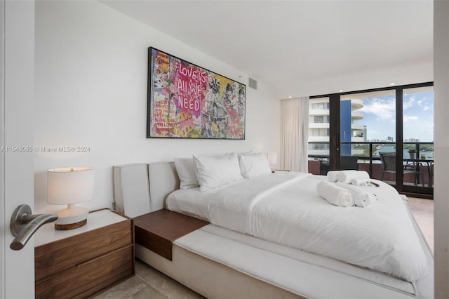 tiled bedroom featuring a wall of windows and access to exterior