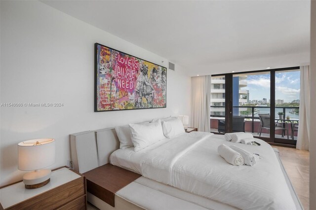 bedroom featuring a water view, light tile flooring, and access to outside