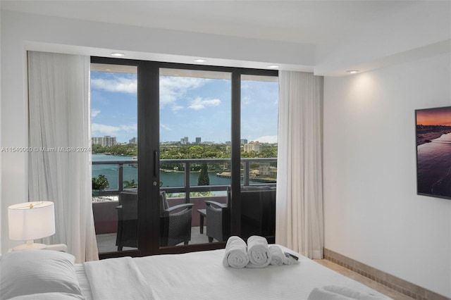 bedroom with a water view and multiple windows