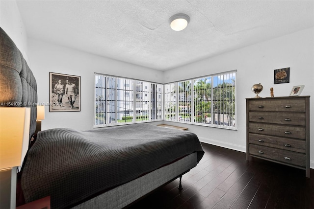 bedroom with dark hardwood / wood-style flooring and a textured ceiling