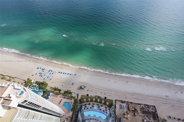 bird's eye view featuring a water view and a beach view