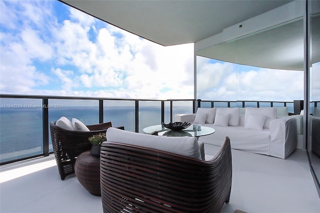 balcony featuring a water view and an outdoor living space