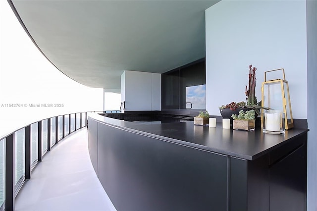 exterior space featuring dark countertops, finished concrete floors, modern cabinets, and dark cabinetry