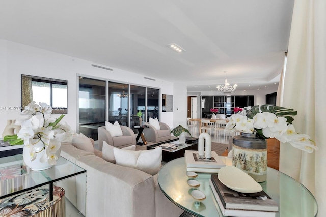 living area featuring visible vents and a chandelier