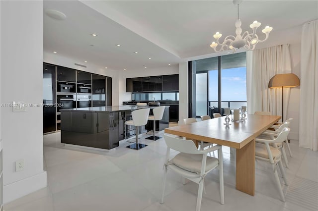 tiled dining room with an inviting chandelier, expansive windows, and a water view