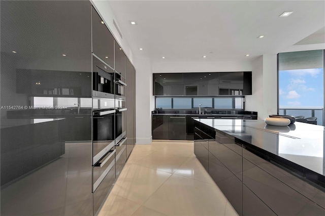 kitchen featuring light tile floors, stainless steel double oven, and sink