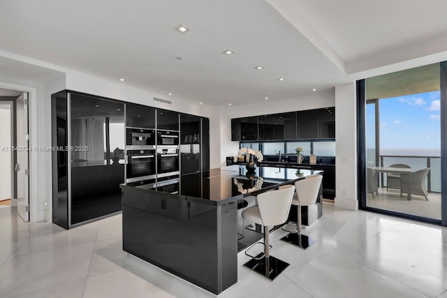 kitchen featuring dark cabinetry, recessed lighting, dark countertops, modern cabinets, and black fridge