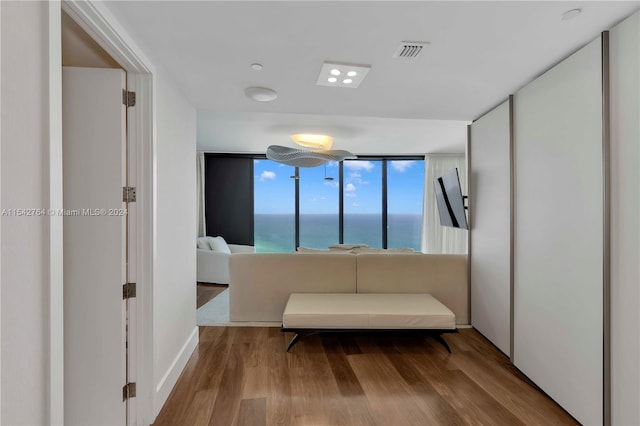 bedroom featuring hardwood / wood-style flooring and a water view