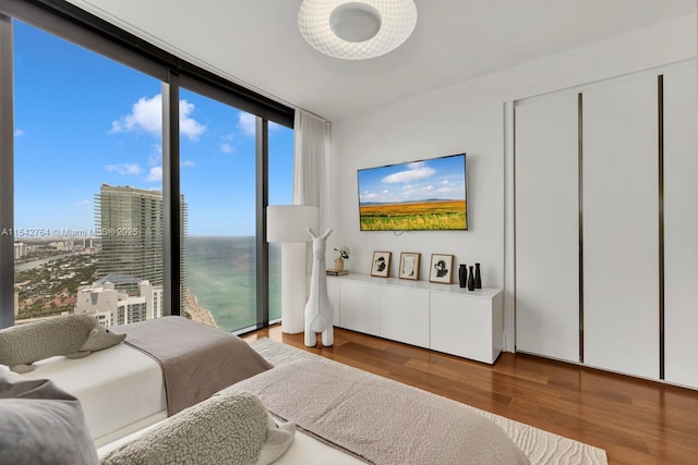 bedroom with wood finished floors and floor to ceiling windows