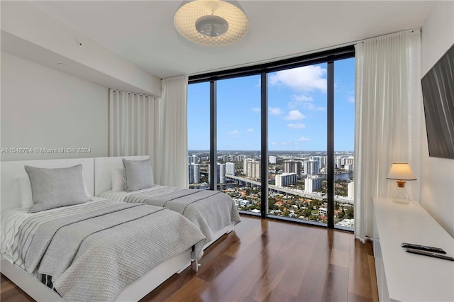 bedroom featuring dark hardwood / wood-style floors and a wall of windows