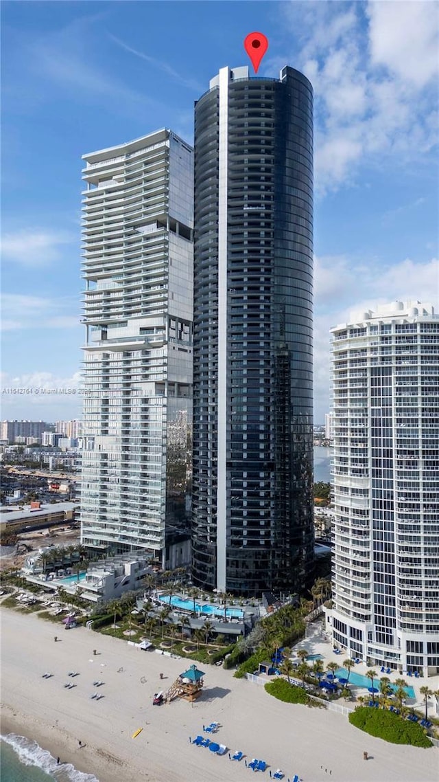 view of building exterior with a view of city, a view of the beach, and a water view