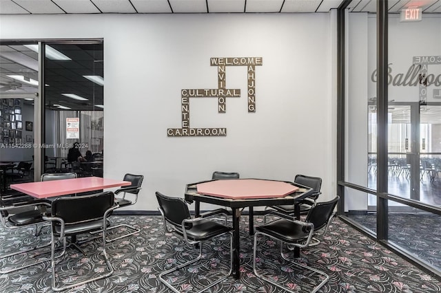 rec room with a paneled ceiling, floor to ceiling windows, and carpet floors