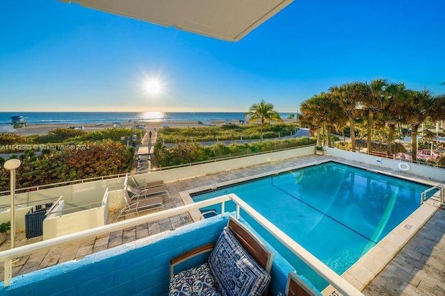 view of pool with a water view and a view of the beach