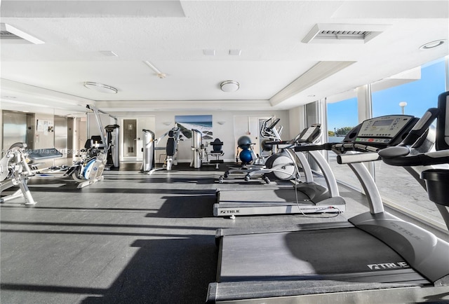 gym featuring a textured ceiling and a wall of windows