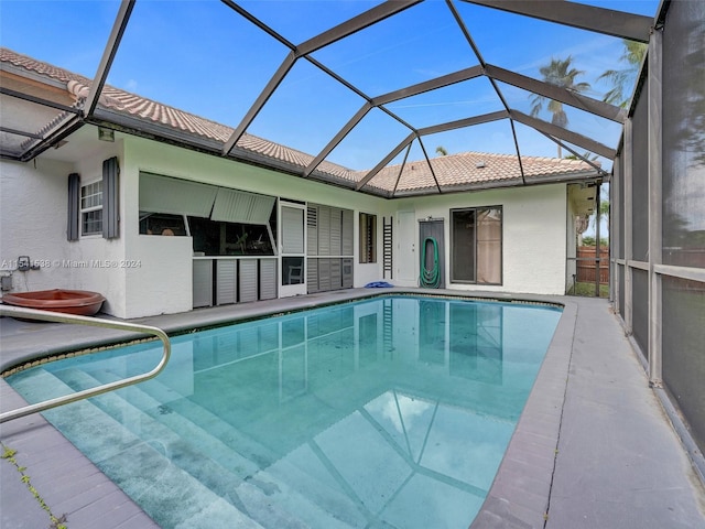 view of swimming pool featuring a lanai