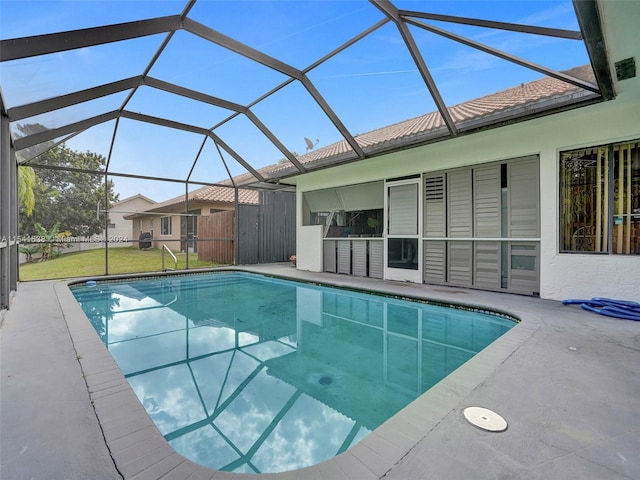 view of pool with glass enclosure, a yard, and a patio area