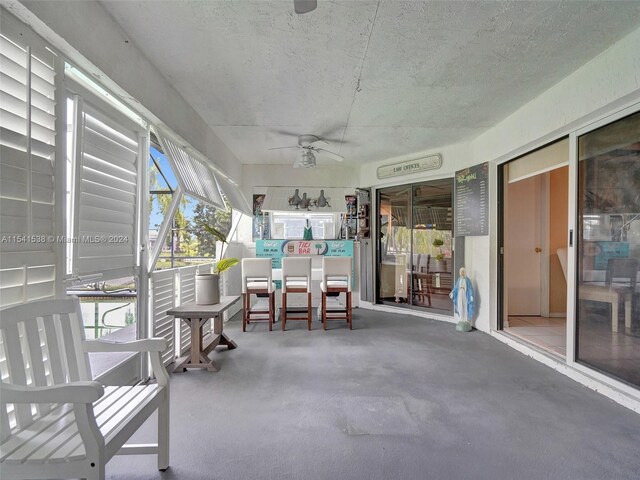 unfurnished sunroom featuring ceiling fan