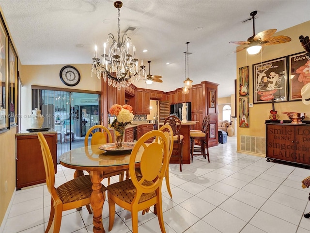 tiled dining room with a textured ceiling, ceiling fan with notable chandelier, and lofted ceiling