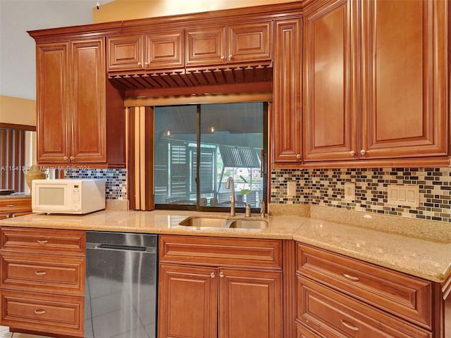 kitchen with tasteful backsplash, light stone counters, dishwasher, and sink