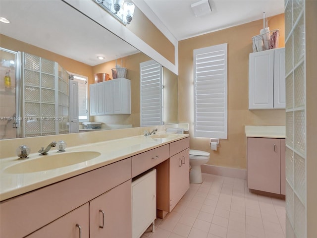 bathroom with toilet, double sink vanity, and tile flooring