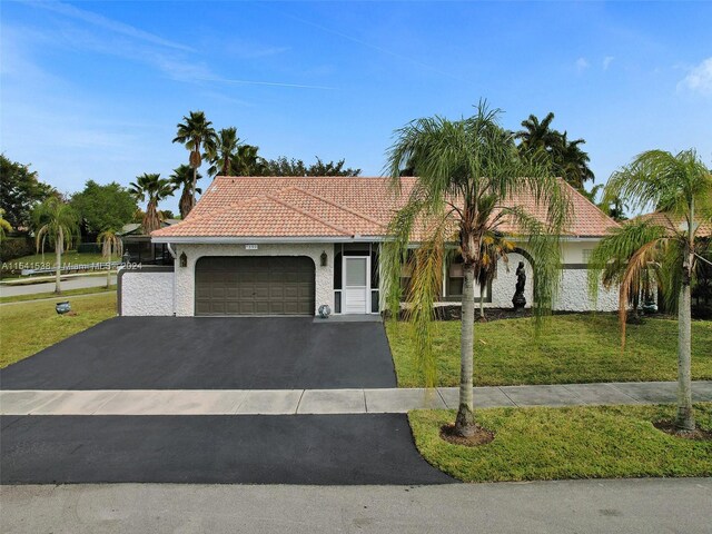 mediterranean / spanish-style home featuring a front yard and a garage