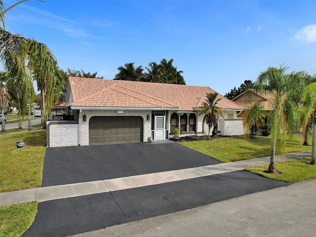 mediterranean / spanish-style house featuring a front yard and a garage