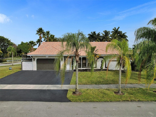 mediterranean / spanish home with a front yard and a garage