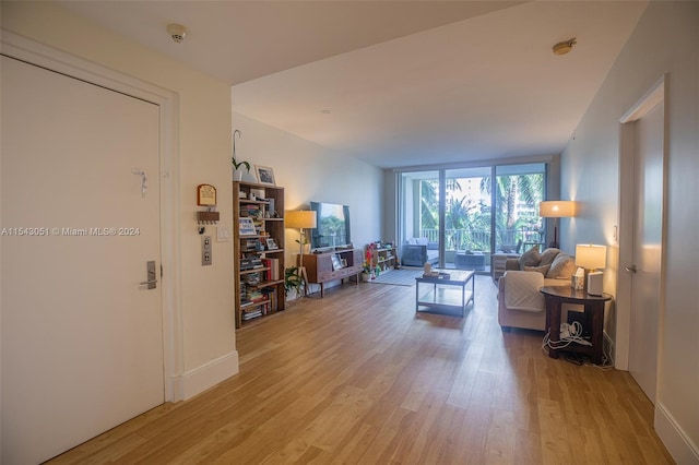 living room featuring expansive windows and light hardwood / wood-style flooring