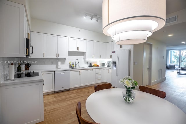 kitchen with tasteful backsplash, light hardwood / wood-style flooring, white appliances, white cabinets, and sink