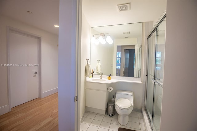 bathroom with toilet, a shower with door, hardwood / wood-style floors, and vanity