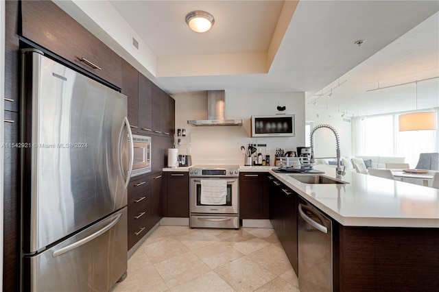 kitchen with wall chimney exhaust hood, dark brown cabinetry, sink, and stainless steel appliances