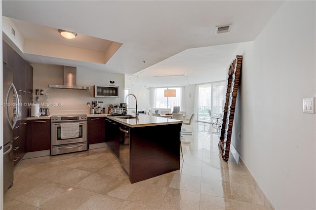 kitchen with light tile floors, wall chimney exhaust hood, sink, and stainless steel appliances