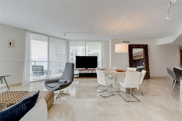 tiled dining area featuring a textured ceiling and rail lighting