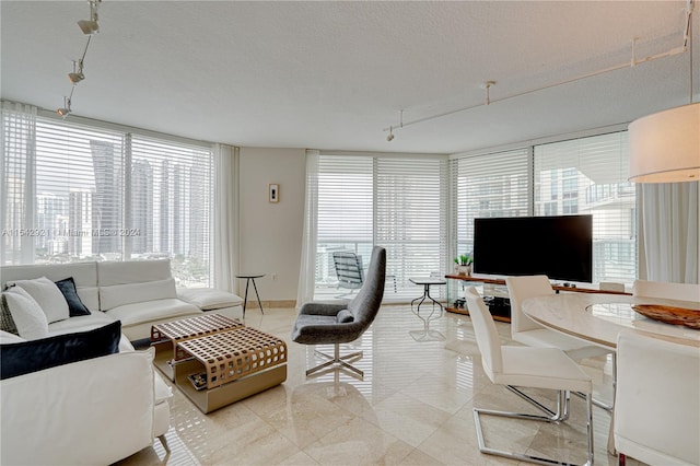 tiled living room with a textured ceiling and rail lighting